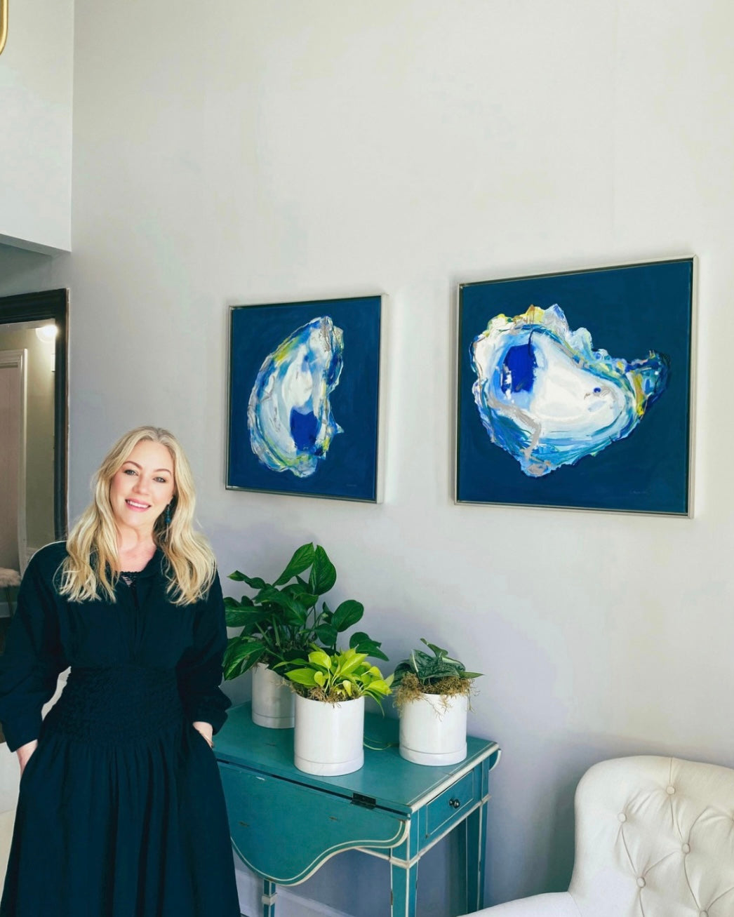 Artist Tara Caswell with original oyster paintings in Charleston, South Carolina.