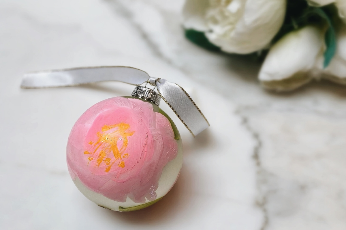 Hand-painted pink glass Christmas ornament by Charleston artist Tara Caswell, finished with a soft ribbon.